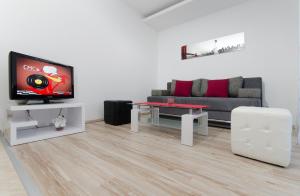 a living room filled with furniture and a tv at City Apartments Nada in Makarska