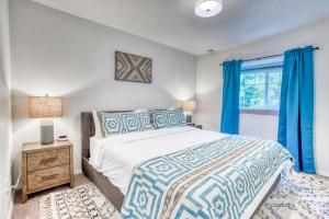 - une chambre avec un lit et une fenêtre avec des rideaux bleus dans l'établissement Seabreeze Getaway, à Warrenton