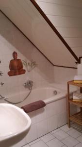 Ein Mann, der in einer Badewanne im Badezimmer sitzt. in der Unterkunft Ferienwohnung Obhausen bei Querfurt in Obhausen