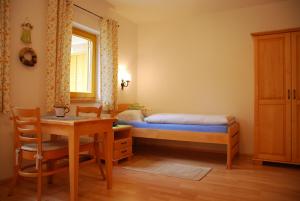 a bedroom with a bed and a table and a desk at Farm Stay Rotovnik - Plesnik in Slovenj Gradec