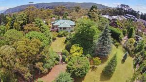 an aerial view of a house on a hill with trees at Mountain Whispers Chatelaine Valley in Katoomba