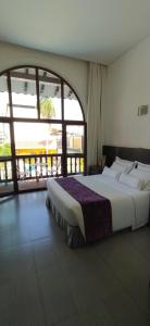 a bedroom with a large bed and a large window at Hotel Union in Girardot