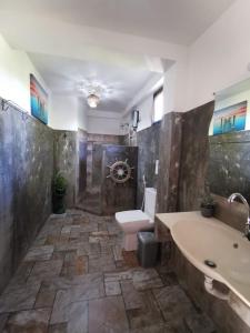 een badkamer met een wastafel, een toilet en een bad bij Blue skies guest house and restaurant in Tangalle