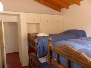 a bedroom with three beds in a room at Cabañas La Rosita in San Agustín de Valle Fértil