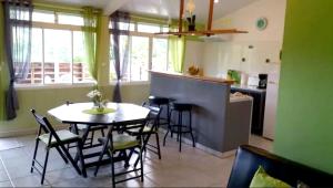 comedor con mesa y sillas en la cocina en Maison de 2 chambres avec jardin clos et wifi a Riviere Salee a 8 km de la plage, en Rivière-Salée