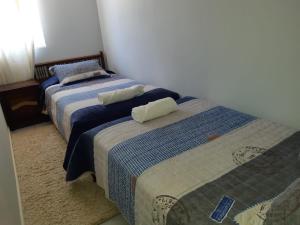 two beds sitting next to each other in a bedroom at Departamento Familiar Los Molles in Los Molles