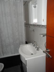 y baño blanco con lavabo y ducha. en Mercedes Rocamora en Colón