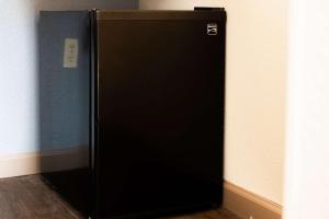 a black refrigerator in the corner of a room at SureStay Hotel by Best Western Fairfield Napa Valley in Fairfield