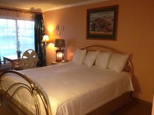 a bedroom with a large white bed with white pillows at Victorian Inn in Reno
