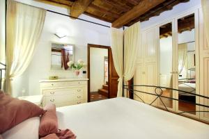 una camera con letto bianco e cassettiera di Aleri a Firenze