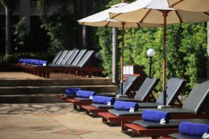 een rij lege stoelen met parasols en trappen bij Deevana Patong Resort & Spa - SHA Extra Plus in Patong Beach