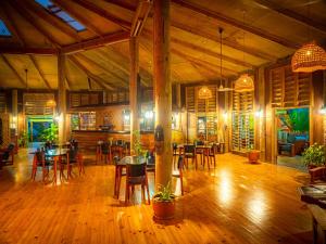 TufiにあるTufi Resortのテーブルと椅子が備わるウッドフロアのレストランを併設しています。