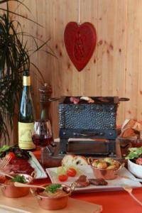 a table with a plate of food and a bottle of wine at Hôtel Panorama in Munster