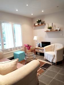 uma sala de estar com um sofá, cadeiras e uma mesa em Maison de 2 chambres a Varaville a 400 m de la plage avec jardin clos et wifi em Varaville
