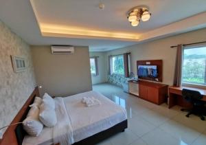 a bedroom with a bed and a desk and a television at Yew Boutique Hotel in Teluk Intan