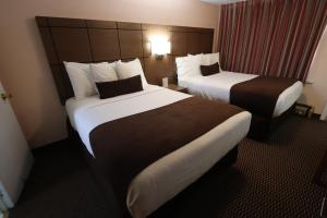 a hotel room with two beds and two lamps at Campbellford River Inn in Campbellford