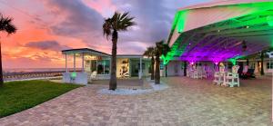 a building with a palm tree in front of the beach at A1A Ocean Club in Flagler Beach