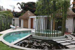 a swimming pool with a fountain in front of a house at Casa Flores Hotel & Spa in Atlixco +38 photos
