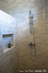 La salle de bains est pourvue d'une douche avec un pommeau de douche. dans l'établissement NON NA PUA - นอนนา ปัว, à Pua