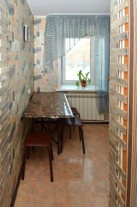 comedor con mesa y ventana en 1 комнатные апартаменты на Садуакасова 24, en Kokshetau