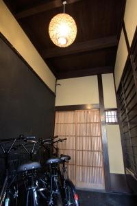 een groep fietsen geparkeerd in een kamer met een licht bij Guest House Hitsujian in Kyoto