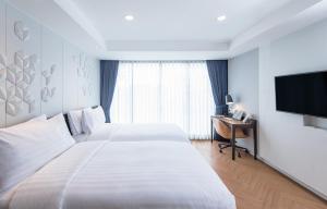 Una televisión o centro de entretenimiento en Amanta Hotel & Residence Sathorn