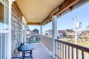 a porch with two chairs and a table on it at Spacious Seaside Home with an Ocean View in Seaside