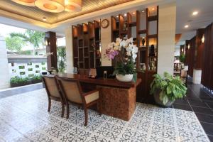 a lobby with a reception desk with flowers on it at Gaing Mas Jimbaran Villas by Gaing Mas Group in Jimbaran