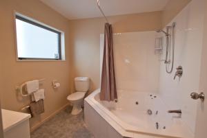 łazienka z wanną, toaletą i umywalką w obiekcie Phoenix Motels w mieście Temuka