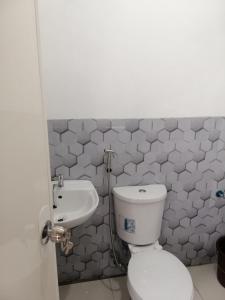 een badkamer met een toilet en een wastafel bij Katrina's Dorm in Tarlac