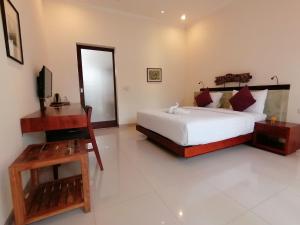 Ubud Bungalow في أوبود: غرفة نوم فيها سرير وتلفزيون