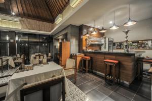 a restaurant with a bar and some tables and chairs at Gaing Mas Jimbaran Villas by Gaing Mas Group in Jimbaran