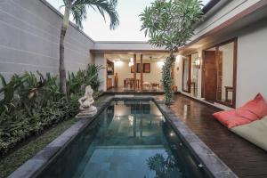 a swimming pool in the middle of a house at Gaing Mas Jimbaran Villas by Gaing Mas Group in Jimbaran