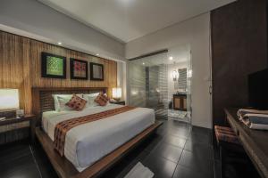 a bedroom with a large bed and a television at Gaing Mas Jimbaran Villas by Gaing Mas Group in Jimbaran