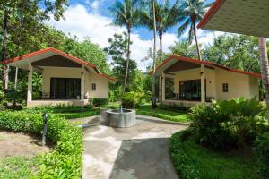 a house with a courtyard and palm trees at Garden Villa Khaolak in Khao Lak