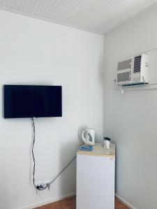 a room with a tv and a refrigerator and a fan at Roebuck Bay Hotel in Broome