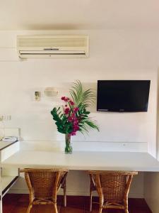 
a table with a vase of flowers next to a television at Roebuck Bay Hotel in Broome
