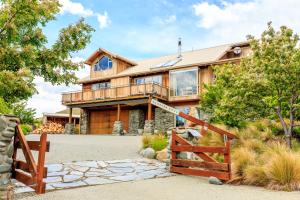 a large house with a fence in front of it at Glacier Rock Lakeview House in Lake Tekapo