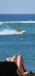 Un par de personas montando una moto acuática en el océano en Besakih Beach Hotel, en Sanur