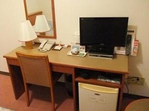 een bureau met een computer, een monitor en een telefoon bij Hotel Kiyoshi Nagoya No.1 in Nagoya