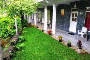 a porch of a house with a yard with plants at My Home Guest in Polonnaruwa