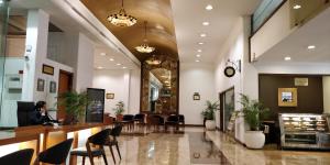 a woman sitting at a counter in a lobby at Hotel Aurora Towers in Pune