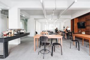 a room with tables and chairs and people sitting at tables at Loyy Hotel in Chiang Mai