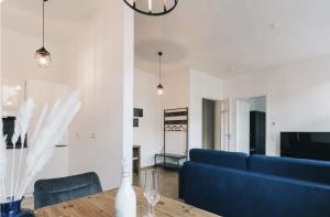 ein Wohnzimmer mit einem blauen Sofa und einem Tisch in der Unterkunft Apartment direkt an der Frauenkirche, Jüdenhof, FEWO-Residenz-Dresden in Dresden