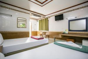 a room with two beds and a flat screen tv at Bualuang Boutique Resort in Ang Thong