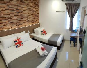 a bedroom with two beds and a brick wall at casa 96 villa in Kuantan