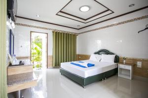 - une chambre avec un lit et un rideau vert dans l'établissement Bualuang Boutique Resort, à Ang Thong