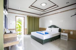 Bualuang Boutique Resort في أنغ ثونغ: غرفة نوم بسرير وستارة خضراء