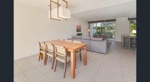 Il comprend une cuisine et une salle à manger avec une table et des chaises en bois. dans l'établissement Magenta Shores 3 Bedroom Villa, à Magenta