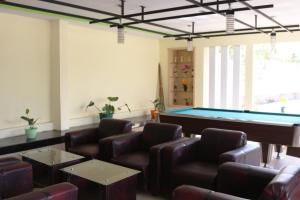 a room with a pool table and leather chairs at Super OYO 1722 Villa Ciparay Indah Syariah in Garut